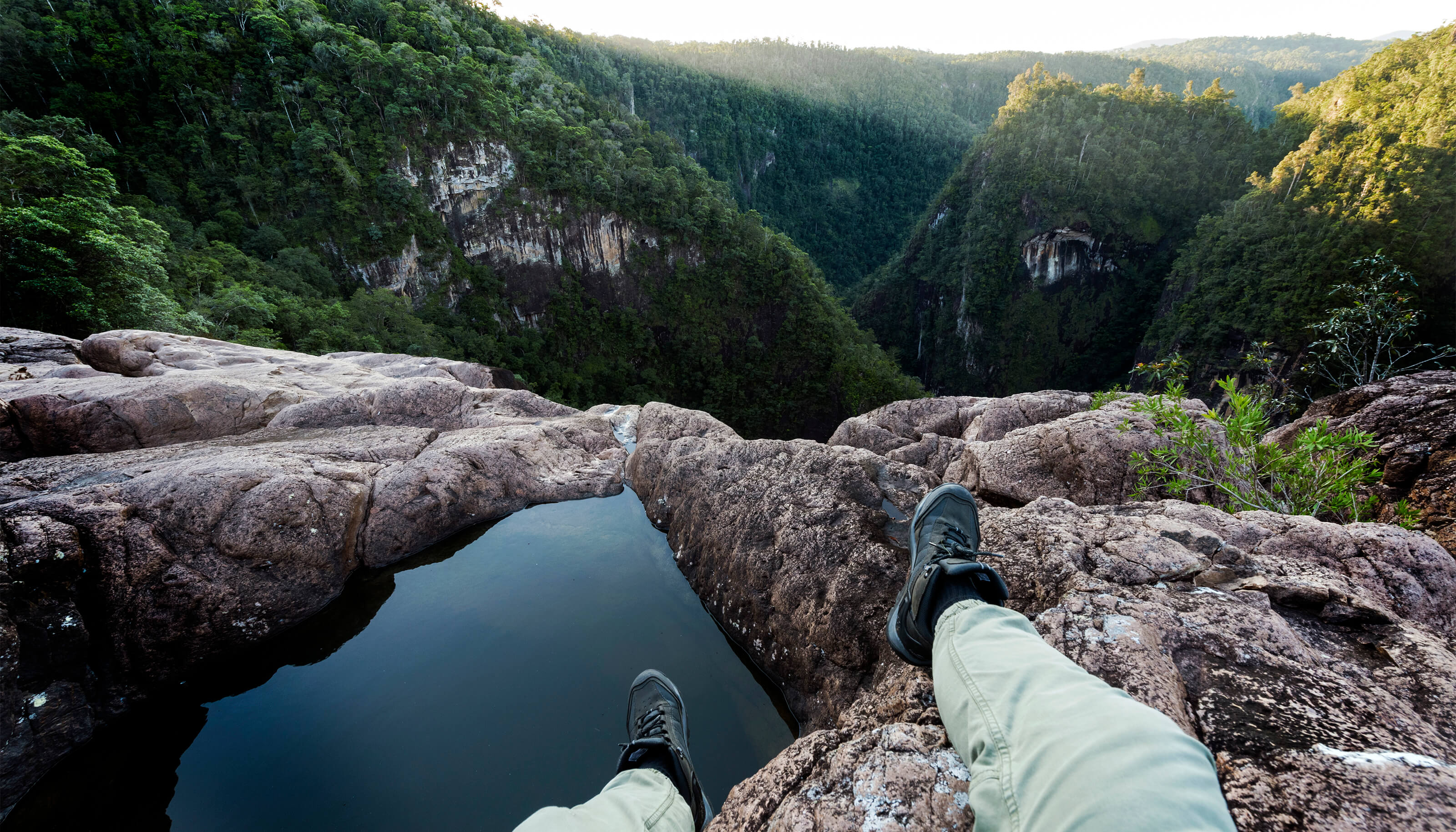 hiker sitting on edge of cliff